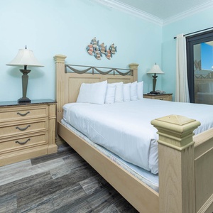 The master suite features an elegant king bed and nightstands, creating a serene atmosphere with balcony access