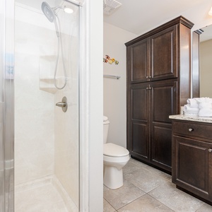 Enjoy a relaxing shower after a day at the beach in this guest bath with stylish cabinetry and spacious vanity