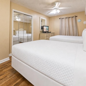Two queen beds in the guest suite invite you to relax and watch a favorite show on the TV after your day