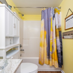 The master bathroom features yellow walls, a stylish granite countertop, and decorative accents for a cheerful atmosphere