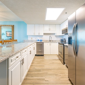 Granite countertops gleam as you prepare fresh meals in the kitchen with stainless steel appliances and wood-style floors