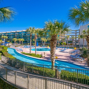 Breathe in the fresh air while soaking in the vibrant pool area surrounded by lush greenery and swaying palms
