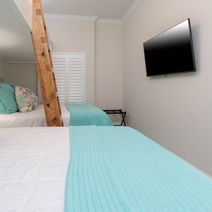 Relax with a bedside lamp between two queens in the guest room with two lofted twin beds above