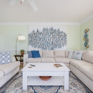 Unwind on the spacious sectional sofa, surrounded by coastal decor and inviting natural balcony light