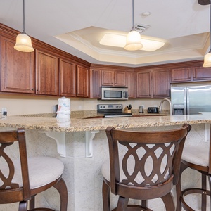Kitchen features granite countertops, stainless appliances, and stylish bar seating for a cozy gathering
