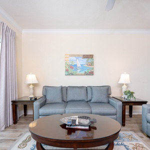 Living room featuring cozy gray sofas with a queen sleeper, decorative artwork, and a lovely coffee table