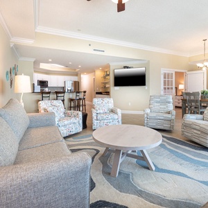 Unwind in the inviting seating area, enjoying family conversations while admiring the inviting coastal view