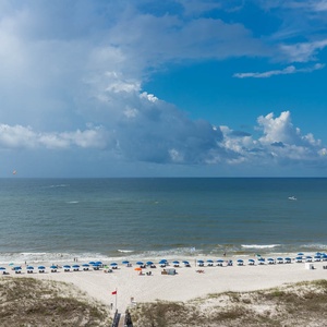 Stunning view of the beach with blue umbrellas lining the shore, inviting guests to relax under the sun