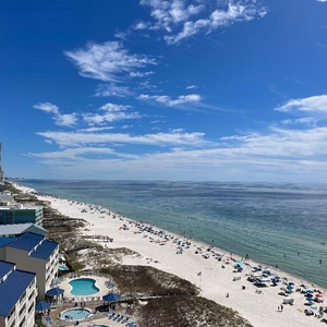 Take in rows of umbrellas along the shore and swimmers wading in the clear gulf from your balcony