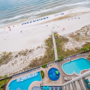 Experience vibrant beachside fun with an inviting pool area and colorful umbrellas just steps from the sandy shore