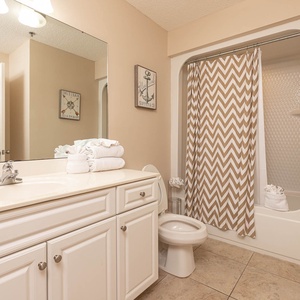 Refresh in this guest bathroom featuring a stylish vanity, stylish towels, and a shower with a chevron curtain