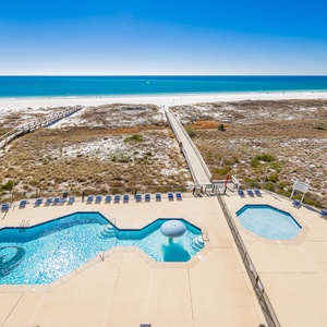 Inviting pool area features sparkling water, mushroom splash fountain, loungers, and easy access to the beach just steps away
