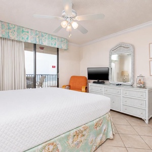 Unwind in the master suite featuring a king bed, a TV, and easy access to the balcony for refreshing beach views