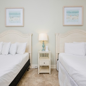 Inviting guest bedroom featuring two plush queen beds, elegant decor, and soft, neutral tones for a relaxing stay