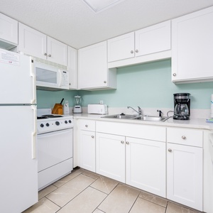 Prepare your favorite meals in this functional kitchen featuring ample counter space and white appliances