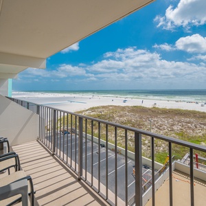 Breathtaking views from the balcony, complete with comfortable seating and a glimpse of the pristine beach below