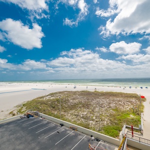 Beautiful view of soft white sands and vibrant blue skies from a beachfront balcony, perfect for relaxation and fun