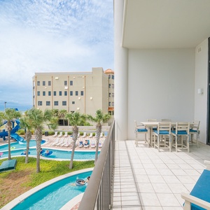 Enjoy the balcony with comfortable seating overlooking the inviting lazy river area and lush palm trees