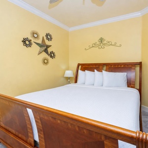 Retreat to this inviting guest bedroom featuring a comfortable queen bed, cheerful yellow walls, and decorative accents