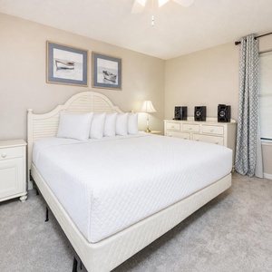 Relax in the inviting bedroom featuring a plush king bed, soft carpet, and stylish decor for a restful night's sleep
