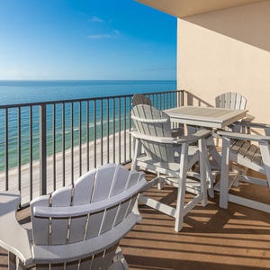 Relax in comfortable seating on the balcony while enjoying expansive views of the tranquil beach