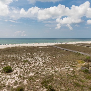 Stunnin view of the beach and turquoise gulf waters, dotted with colorful umbrellas and beachgoers