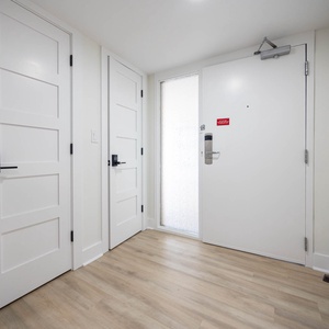 Bright entryway featuring sleek white doors and light wood flooring, creating a welcoming atmosphere