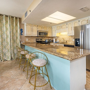 Granite breakfast bar invites casual chats while the kitchen welcomes your culinary creations