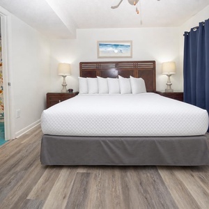 The master bedroom features a plush king bed with decorative pillows, soft lighting, and a vibrant bathroom just steps away