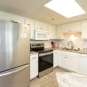 Prepare meals in this bright kitchen featuring white and stainless appliances and stylish cabinetry