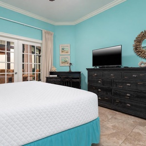 The master features a calming turquoise wall, a TV for entertainment, and convenient work desk area with complimentary WiFi
