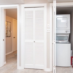 The laundry area features convenient stacked appliances and a clean, bright design, perfect for easy vacation upkeep