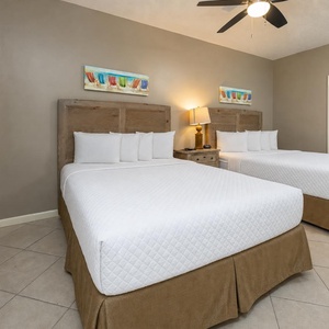 Inviting guest bedroom featuring two double beds, stylish decor, and a warm atmosphere for restful nights