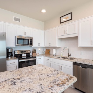 The kitchen offers plentiful appliances, granite countertops, and a charming decor, perfect for meal prep and entertaining