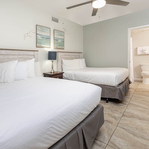Relax in this inviting guest bedroom featuring two queen beds and soft linens, perfect for a restful night's sleep