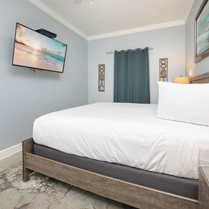 Cozy guest bedroom featuring a king bed, a TV for entertainment, and soft linens