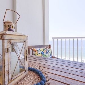 This inviting balcony features a rustic lantern and a beautiful beach view, perfect for relaxing moments
