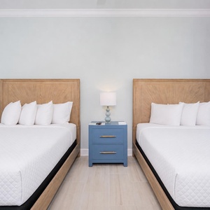 Rest in this queen guest room with fluffy pillows and a relaxing vibe