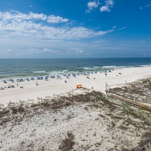 Expansive shoreline, where colorful umbrellas provide shade for guests enjoying the warm beach atmosphere