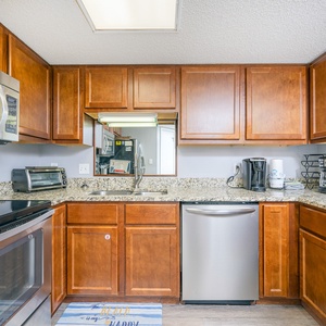 Prepare meals in this inviting kitchen featuring granite countertops, stainless appliances, and wooden cabinetry