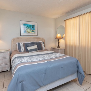 This bedroom features soft blue and beige tones, a comfortable bed, and warm lighting for a relaxing retreat