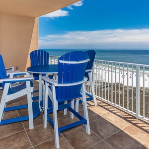 Relax on the balcony's blue chairs, savoring the gentle breeze and stunning views of the coast below
