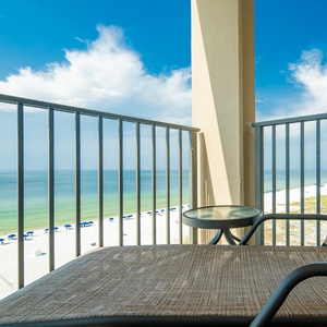 Relax in the comfortable chair on your balcony, soaking in the serene views of the tranquil waters and beach below