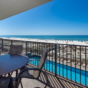 Savor meals or relax on the balcony with comfortable seating and views of the beach and inviting pool below