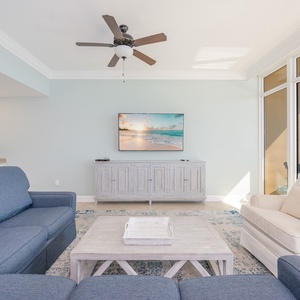 Relax on the plush couch with a queen sleeper as gentle breezes flow from the balcony, filling the space with coastal charm