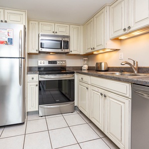 This kitchen features stainless appliances, granite countertops, and ample cabinetry for a delightful cooking experience