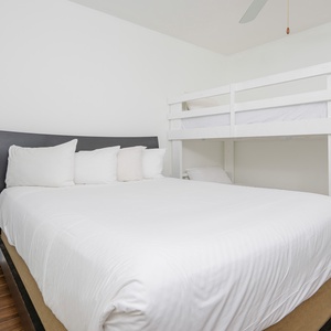 Cozy guest bedroom featuring a comfortable queen bed and a charming twin bunk bed, perfect for families or friends
