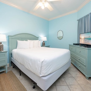 Relax in this tranquil guest bedroom featuring a comfortable queen bed, stylish decor, and a TV for your entertainment