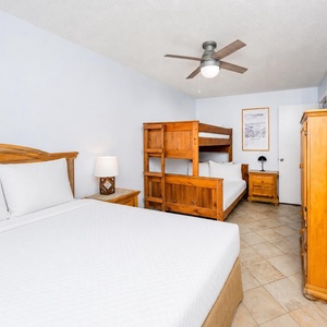 The guest room features a double bed, a cozy twin over full bunk bed, a flat-screen TV, and warm wood furnishings