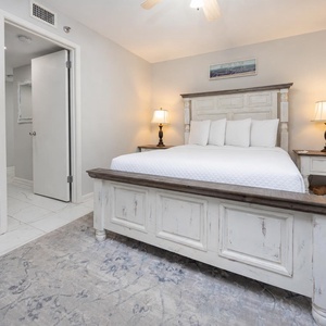 Guest bedroom featuring a queen bed with plush white linens, a stylish nightstand, and soft lighting for relaxation